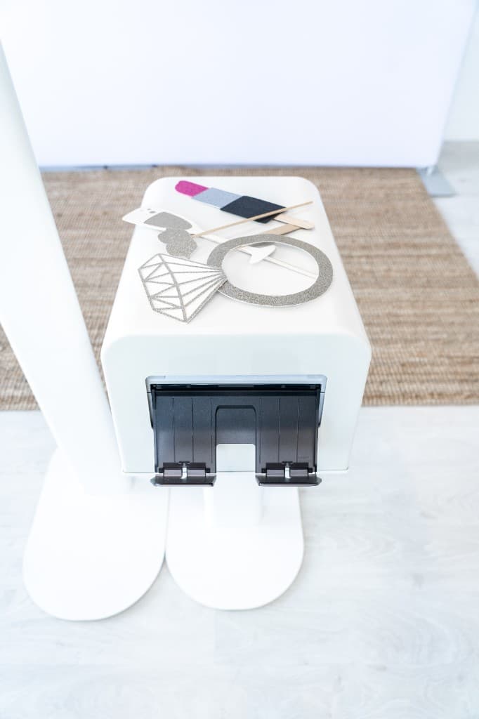 Photo booth with props — glitter mustache, lips, hearts